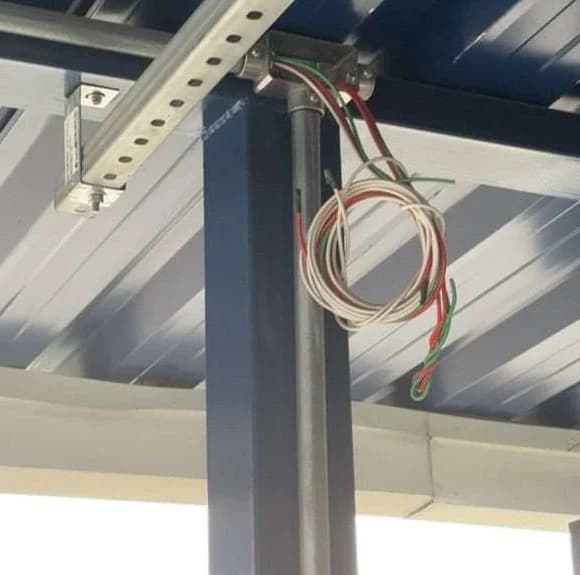 Condutores elétricos aparentes e sem proteção junto a estrutura metálica de cobertura