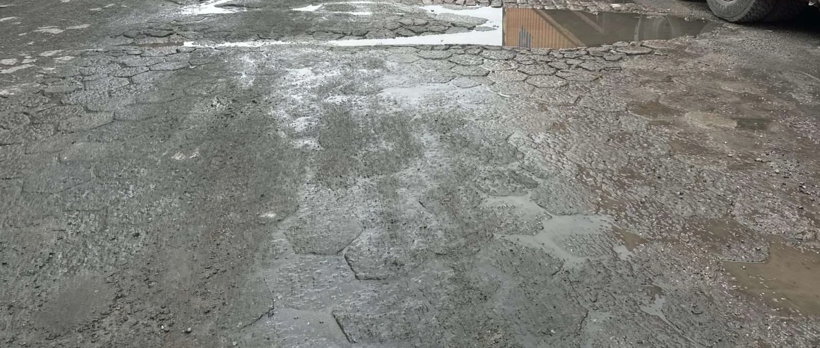Pavimento operacional deteriorado com irregularidades e água acumulada